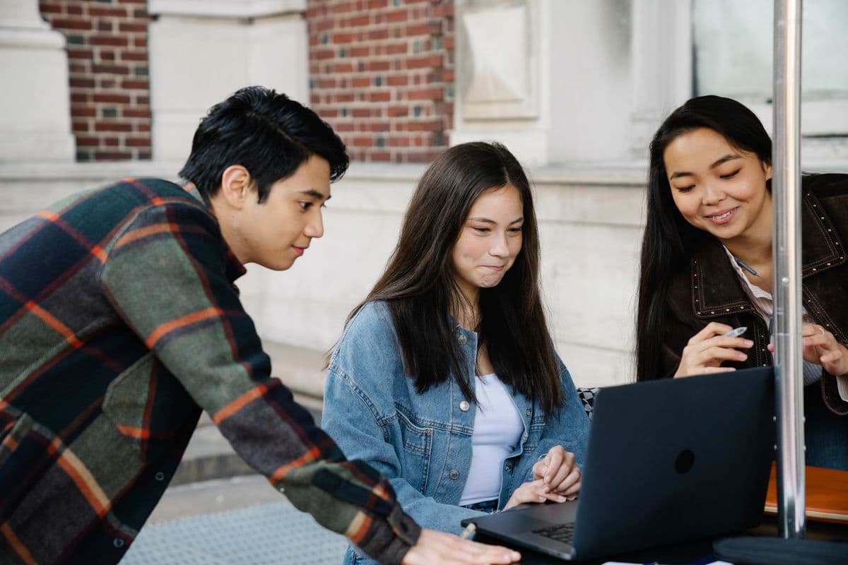 University students collaborating around a laptop
